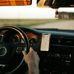 Interior of a car with GPS navigation, focusing on the driver and dashboard during the day.